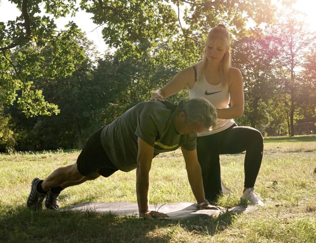 Fitness Trainer Dresden hilft Kunde bei Übungen